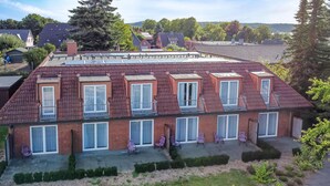 A multi-story residential building with multiple balconies and a flat roof with solar panels. - Hotel Wittensee (Gross Wittensee)