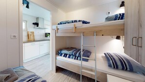 A bunk bed room with a kitchen area visible through an open door. - Beautiful Ship/boat in Aalsmeer With 2 Bedrooms and Wifi (Aalsmeer)