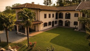 Un edificio grande su due piani con un cortile interno, caratterizzato da una facciata in pietra, numerose finestre e un tetto in tegole.