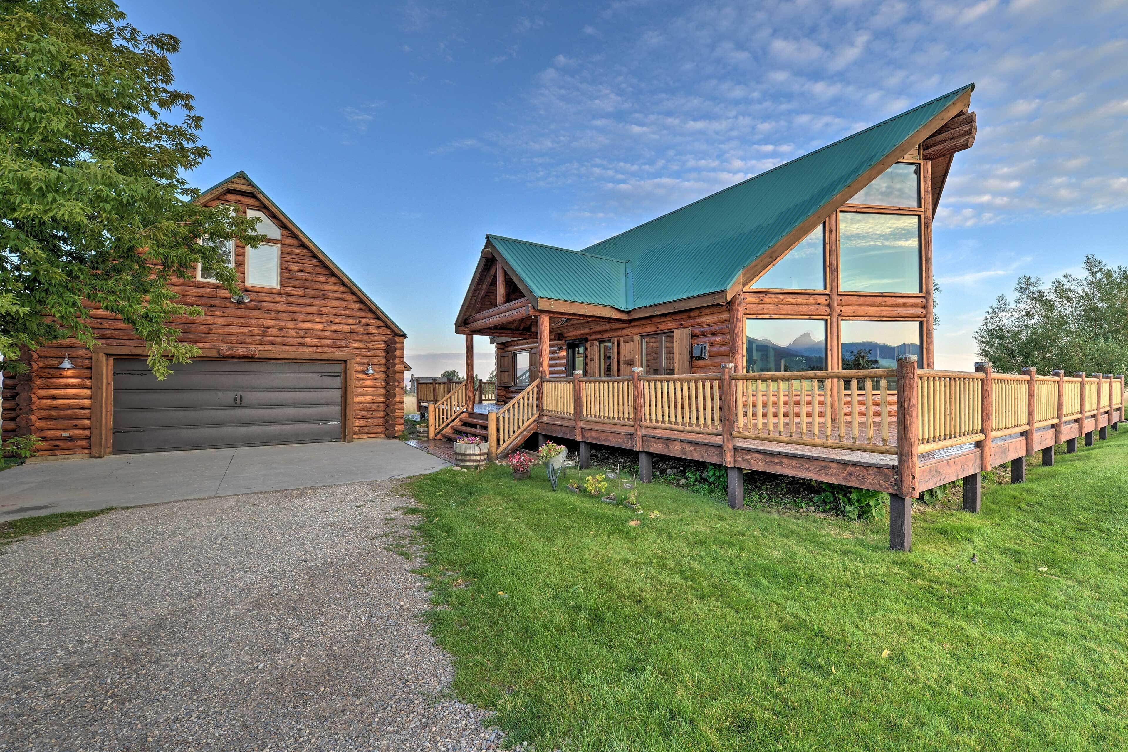 A log cabin with a covered deck and a garage.