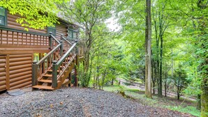A log cabin with a wooden staircase leading to a deck, surrounded by dense forest. - 'Deer Haven' Cabin: 5 Mi to Dtwn Blue Ridge! (Blue Ridge)