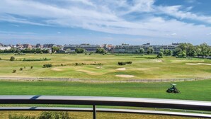 A golf course with a view of buildings in the background. - Royal Ascot S2 Ref. 8 (Ostend)