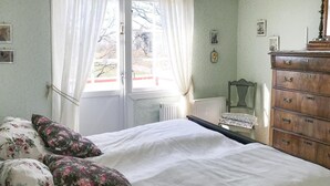 A bedroom with a bed, floral pillows, a dresser, and a chair. - Amazing Home in Degerhamn With 2 Bedrooms and Wifi (Degerhamn)