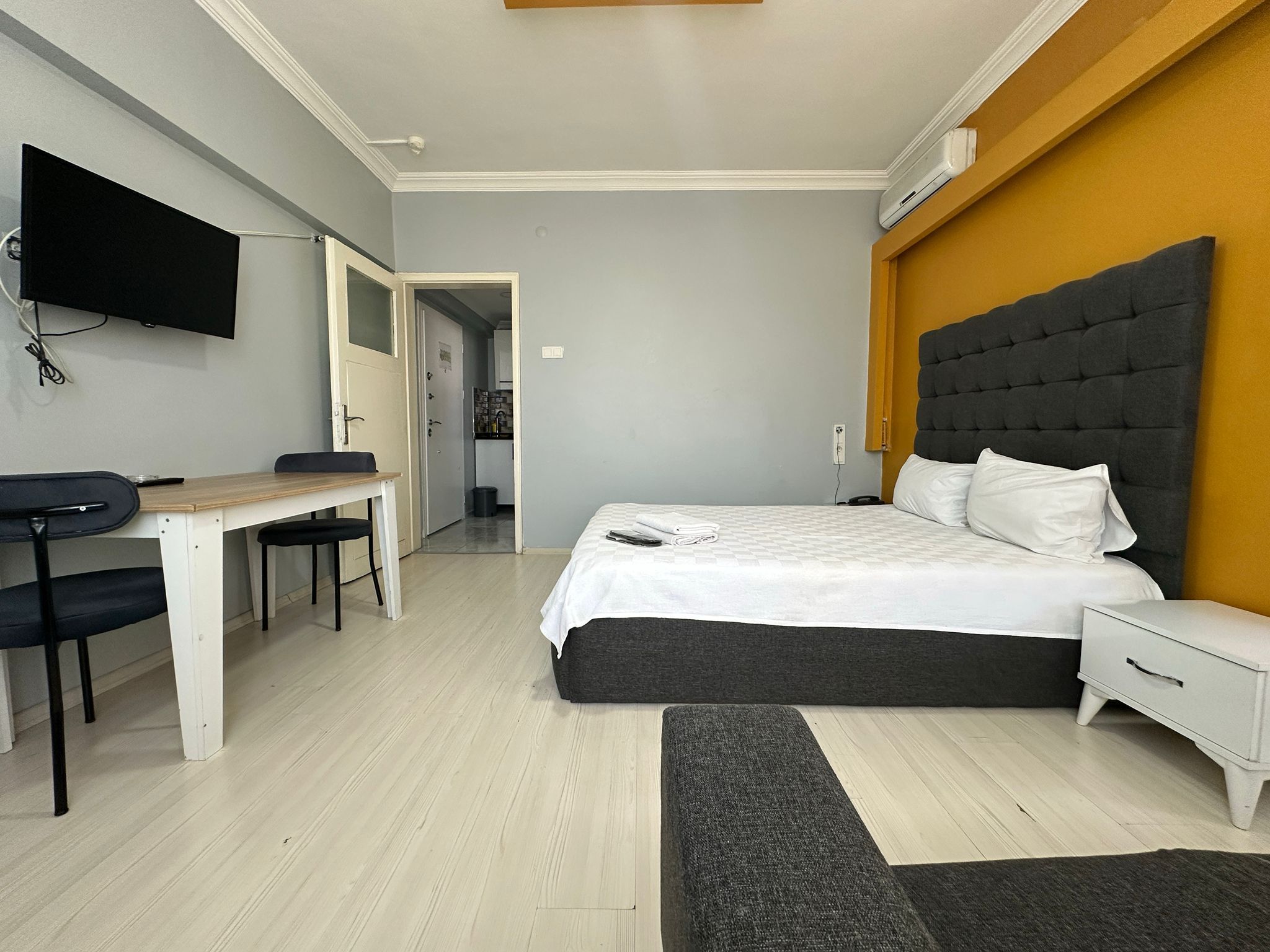 Een moderne slaapkamer met een bed, nachtkastje en bureau met stoel.