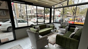 A modern interior with a green sofa, a grey armchair, and a patterned rug. - YILDIRIM SUİT APART OTEL (Ankara)