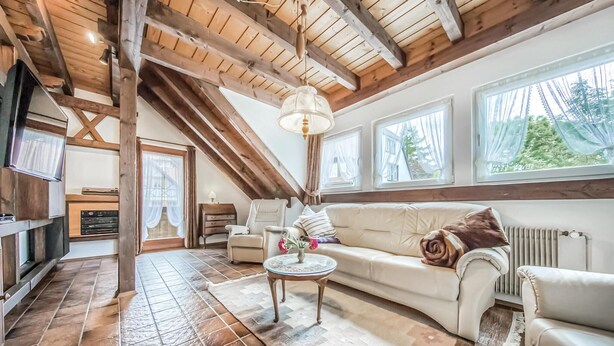 A cozy living room with a high ceiling, wooden beams, a sofa, a coffee table, and large windows. - Nice Apartment in Schonach With 2 Bedrooms and Wifi (Schonach im Schwarzwald)