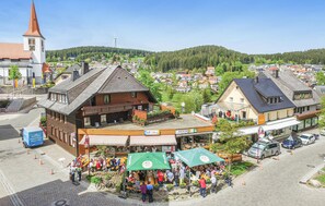 A town square with a traditional building, a church, and a market area with people and food stalls. - Nice Apartment in Schonach With 2 Bedrooms and Wifi (Schonach im Schwarzwald)
