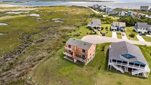 A coastal residential area with houses, a beach, and a large body of water.