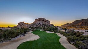 A golf course with a prominent rock formation in the background, surrounded by sparse vegetation and a few buildings. - The Boulders Villa-Scottsdale-Private Pool/Spa-Golf⛳️ (Scottsdale)