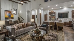 A spacious living area with a sofa, chairs, a coffee table, and a kitchen with a bar. - The Boulders Villa-Scottsdale-Private Pool/Spa-Golf⛳️ (Scottsdale)
