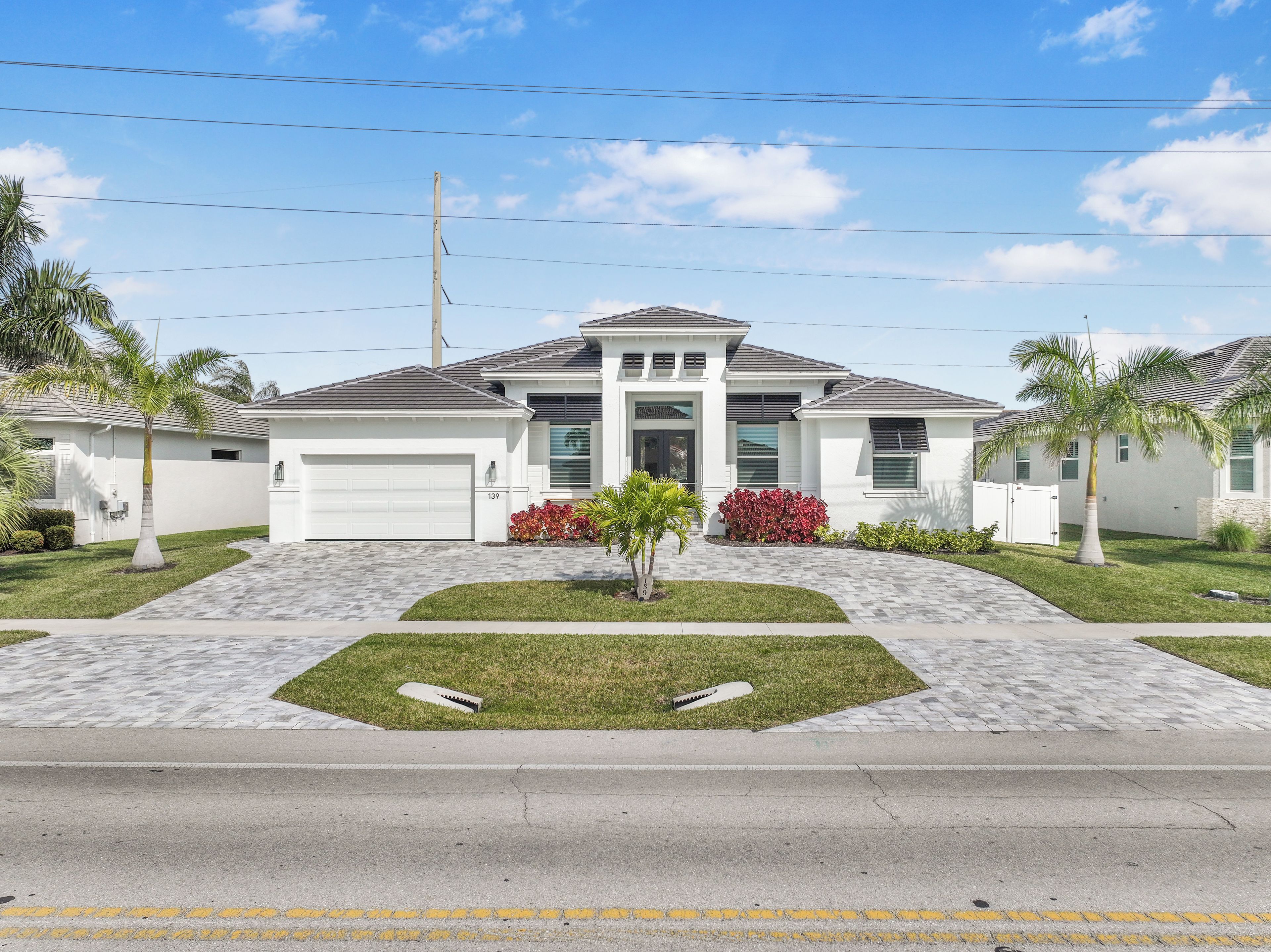 A two-story house with a garage, a driveway, and a well-maintained lawn.