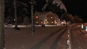 A snow-covered landscape with a house in the background.