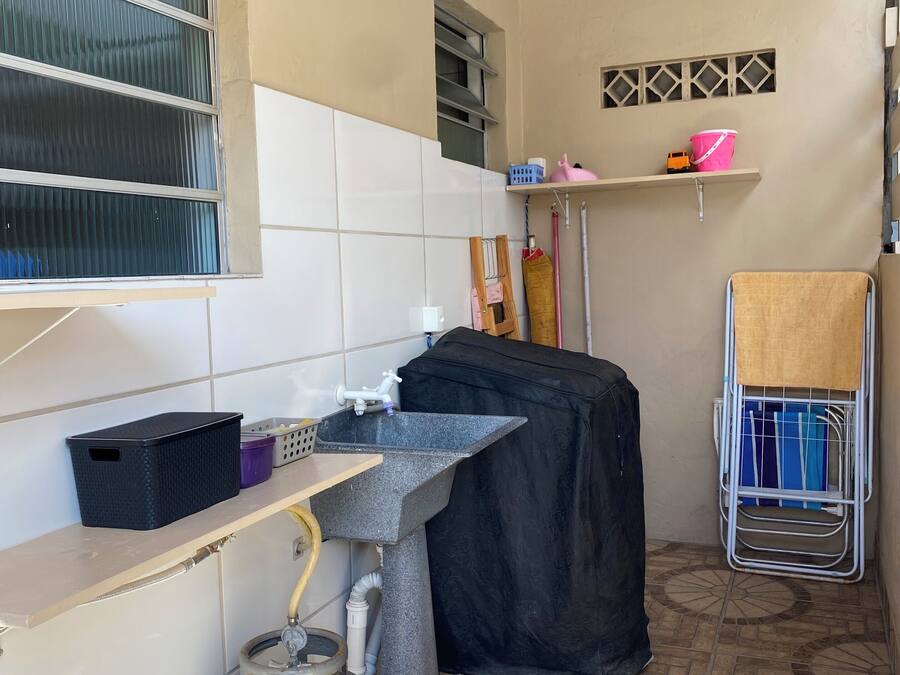 A compact kitchen with a gas stove, a sink, and a tiled backsplash.