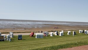 A beachside caravan park with rows of caravans and a grassy area in the foreground. - Friedrichskoog/deichblick 7 (Friedrichskoog)