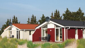 Rivi punavalkoisia mökkejä, joissa on satelliittiantennit, ja hiekkainen polku johtaa sisäänkäynnille.