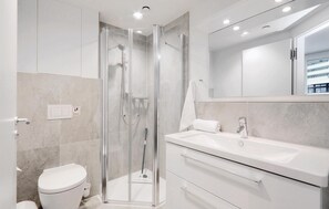 A modern bathroom with a glass-enclosed shower, a white toilet, and a large vanity with a mirror. - Awesome Apartment in Lübeck Travemünde With 1 Bedrooms and Wifi (Lübeck)