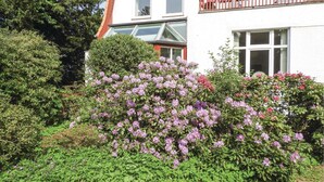 A white building with multiple windows and a balcony with a red railing. - Stunning Apartment in Lübeck With Wifi (Lübeck)