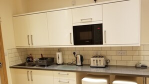 A kitchen with white cabinets, a Bosch microwave, a toaster, and a kettle. - London Luxury Apartment 1 Bed Studio 1 min walk to Redbridge Tube Station (Ilford)