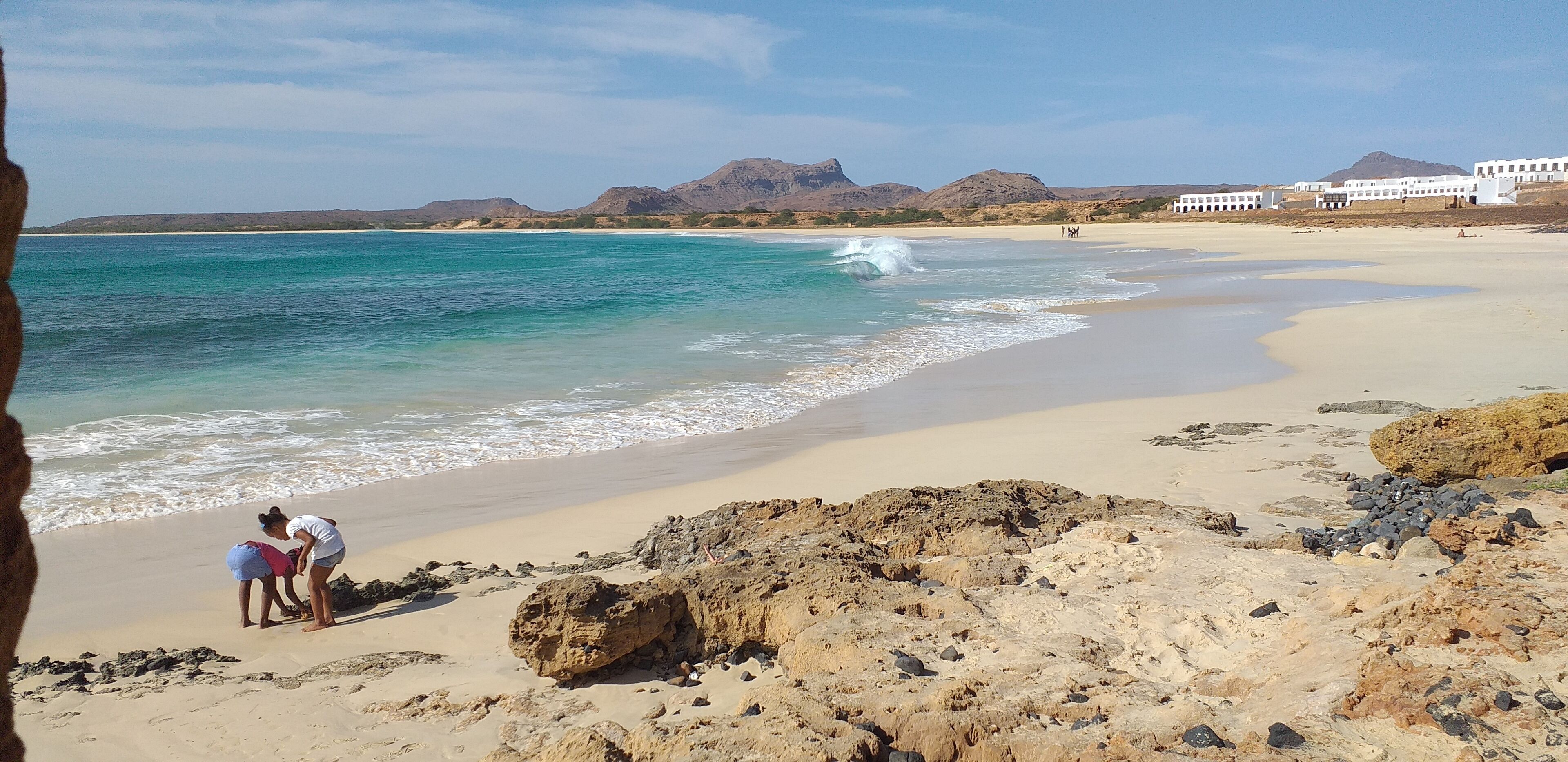 A beach with rocky terrain and a clear view of the ocean.