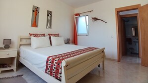 A bedroom with a bed, a ceiling fan, a nightstand, a window with curtains, and a door leading to another room. - The Yellow Flat - Sea View (Boa Vista)