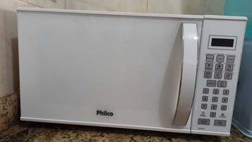 A white Philco microwave oven with a digital display and control panel on a granite countertop.