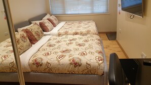 Camera da letto con due letti, una televisione e una scrivania.