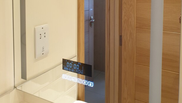 Un bagno con uno specchio, un lavandino e una porta in legno.