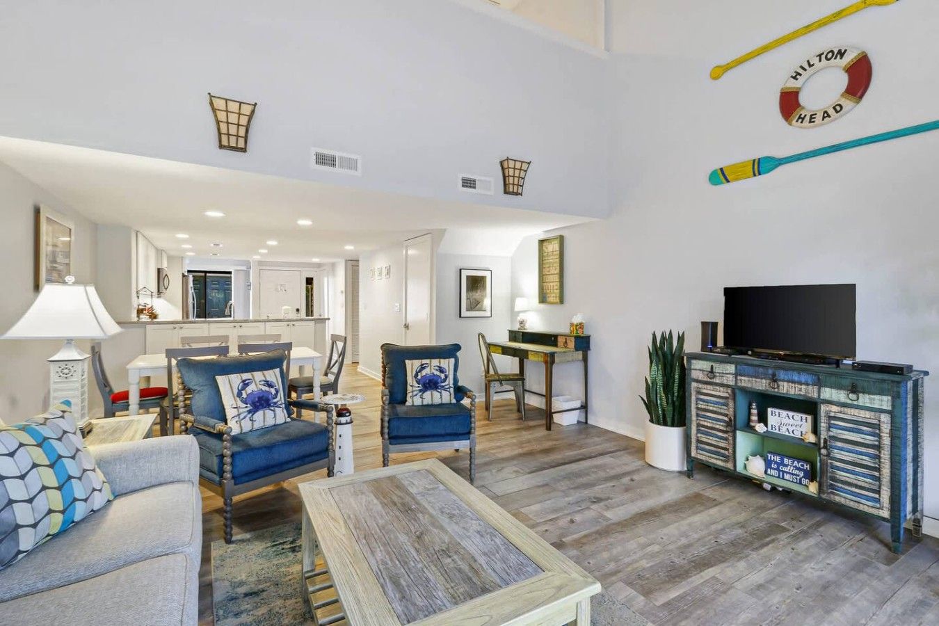 A spacious living area with a television, seating, and a decorative wall piece.
