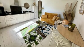 Una cocina moderna con armarios blancos, encimera negra y horno empotrado.