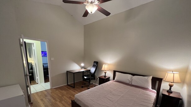 A bedroom with a bed, two bedside tables with lamps, a desk with a chair, and a ceiling fan. - Cheerful 2 Bedroom Home w/Parking in Central South Austin Pet Stays for Free ! (Austin)