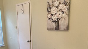 A room with a wooden floor, a white door, and a wall-mounted storage unit with fabric drawers. - Cheerful 2 Bedroom Home w/Parking in Central South Austin Pet Stays for Free ! (Austin)