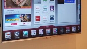 A TV screen displaying a streaming service interface with various content options and a movie playing.