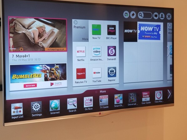 Una pantalla de televisor mostrando la interfaz de un servicio de streaming con varias opciones de contenido y una película en reproducción.