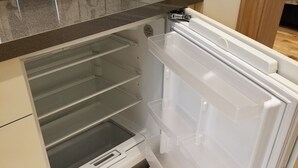 A modern kitchen with a built-in refrigerator, a toaster, and a stainless steel sink.