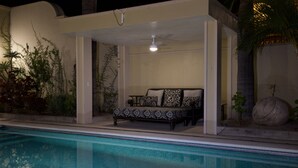A poolside area with a sofa and a ceiling fan. - Lake Front (Ajijic)