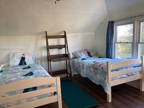 A room with two wooden bunk beds, a ladder, a window with curtains, and a view of trees outside. - Entire home w 100 Acre+ hunting space (Lake Huntington)