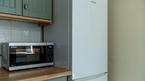 A kitchen with a microwave and a refrigerator. - Spacious Pet Friendly 2-bed Apartment in Redhill (Redhill)