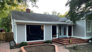 A single-story house with a brick patio, a covered porch, and a small garden area. - Historic 3-bedroom Cloverdale Home next to Playhouse (Montgomery)
