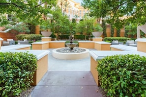Escape to a serene oasis surrounded by lush greenery and a soothing fountain.
