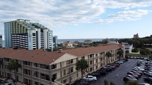 A hotel with multiple floors, a parking lot, and a view of the sea. - Charming Studio Condo Steps From Beach - Sleeps 4 (Myrtle Beach)