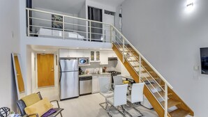 A modern apartment with a kitchen, dining area, and a staircase leading to an upper level. - Modern Downtown Vancouver Loft. Parking included.  (Vancouver)