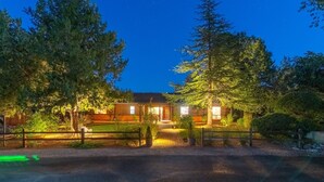 Een tweelaags landhuis met een goed verlichte ingang en een overdekte veranda.