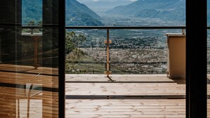 A room with a large window overlooking a mountainous landscape. - Ruhiges Loft in der Natur mit Fantastischem Blick auf Meran (Dorf Tirol)
