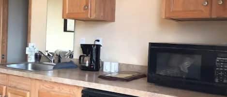 Fridge, microwave, coffee/tea maker, cookware/dishes/utensils