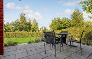 Relax in a serene outdoor space surrounded by lush greenery and a clear sky.