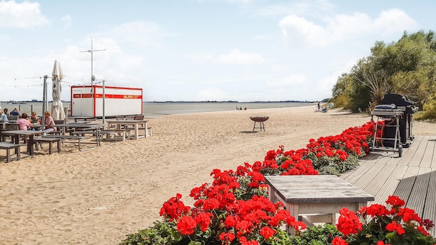 Ein Restaurant direkt am Strand mit Terrassensitzplätzen, einer überdachten Zone und Meerblick.