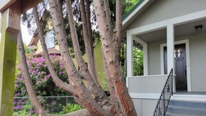 A house with a large tree in the front yard, a porch, and a staircase leading to the front door. - Modern Craftsman Garden Patio (Seattle)