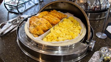 Breakfast buffet with scrambled eggs and baked goods.