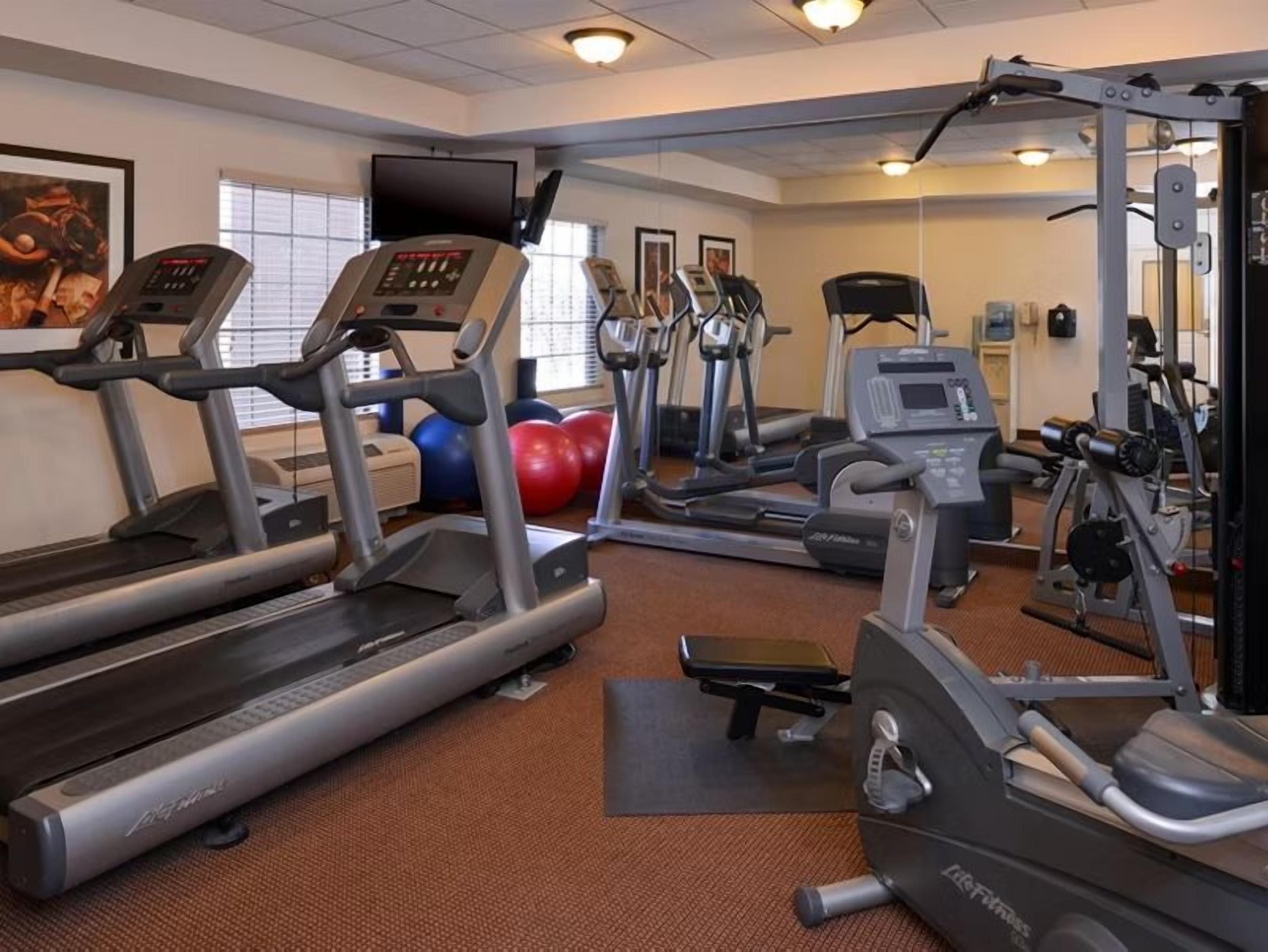 A gym with treadmills, elliptical machines, and weight equipment.