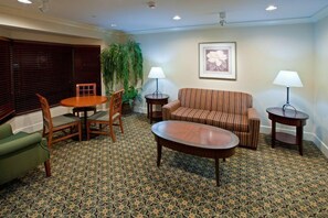 A hotel room with a round table, two chairs, a sofa, a coffee table, and a lamp. - Studio | Free Breakfast + Outdoor Pool (Plainfield)